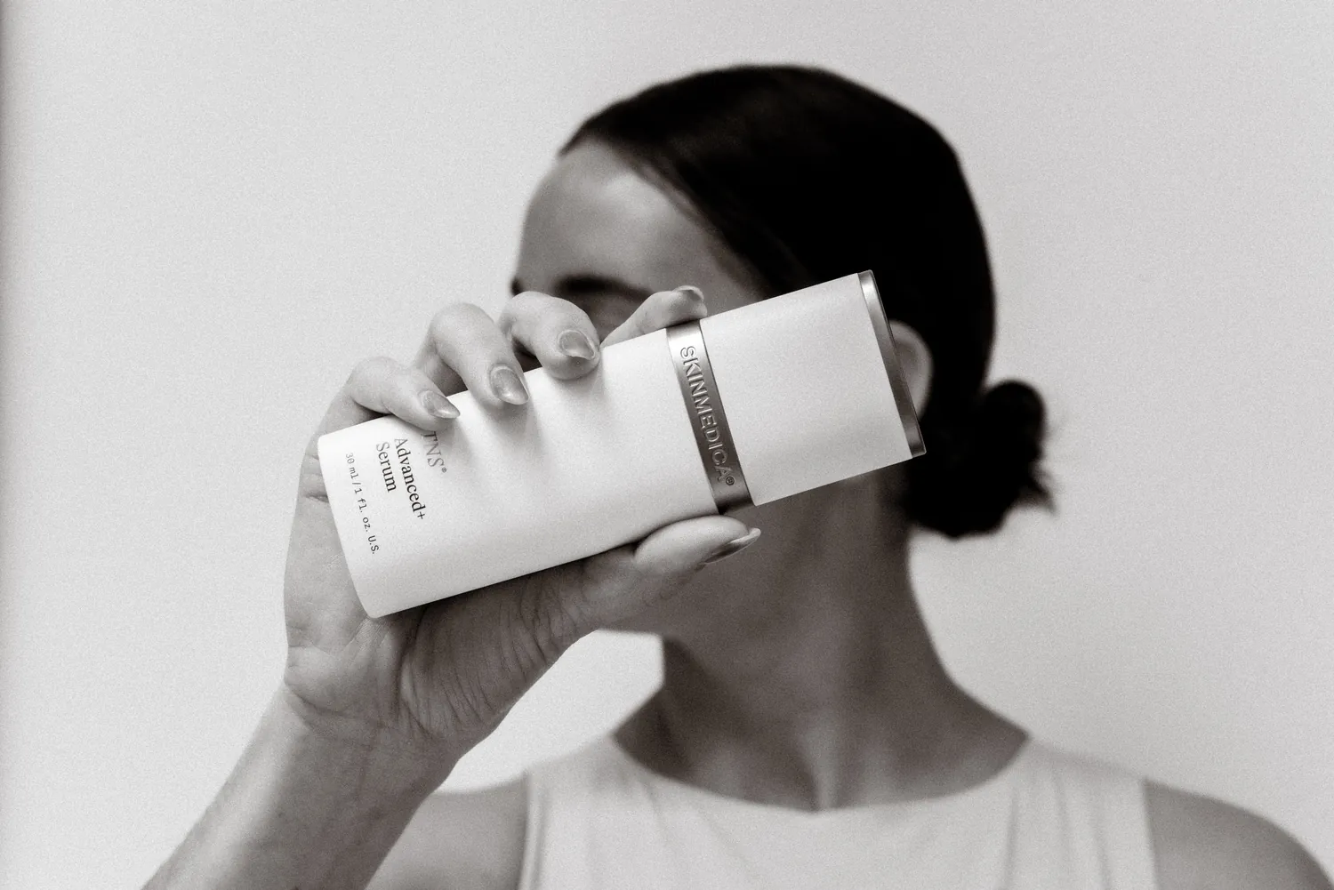 Black-and-white portrait with skincare product